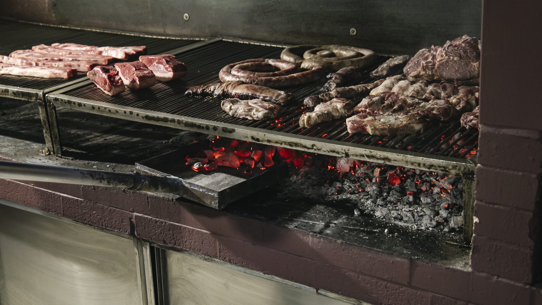 Griglia con carne e salsicce sulla brace viva - la Tranquera Osteria